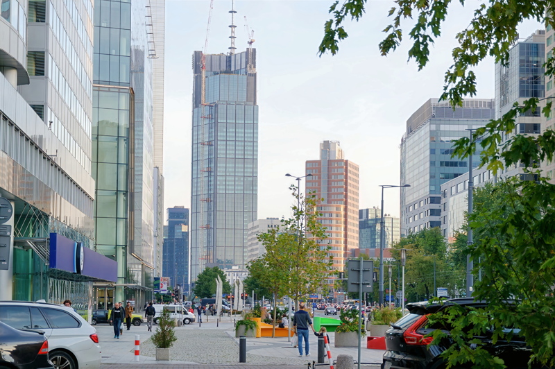 26 - A modern urban streetscape in Warsaw, Poland, featuring the prominent Varso Tower under construction in the background